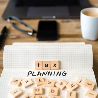 Lettered tiles scattered on a notepad that spell out Tax Planning.