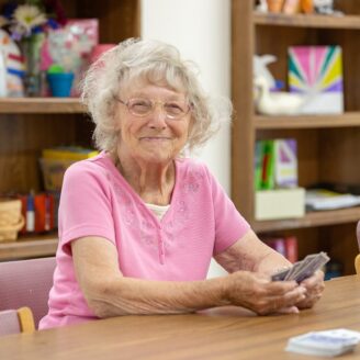 Senior citizen plays cards at Daybreak Adult Day Services