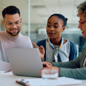 couple sits with an advisor looking at a laptop