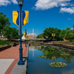 A manicured waterway that runs through brick walkways.