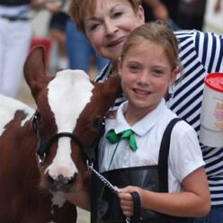 Fran Murray stands with her niece and a calf at a 4H fair event